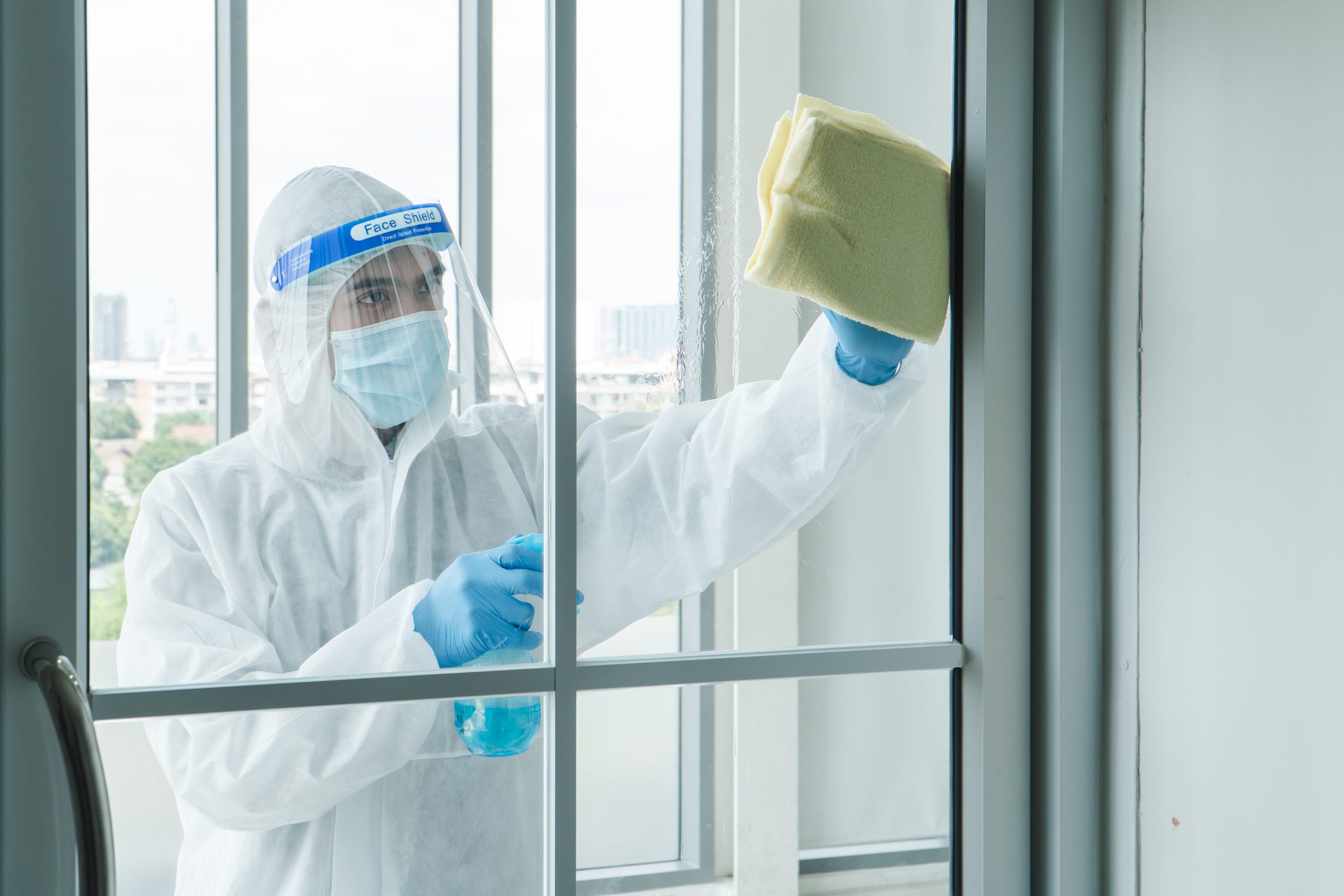 Person cleaning window in protective gear